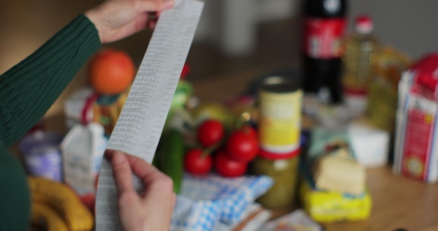 A close-up shot of a grocery store receipt with a visible total reflecting higher prices. The background is blurred to focus on the receipt and the impact of inflation on everyday purchases.