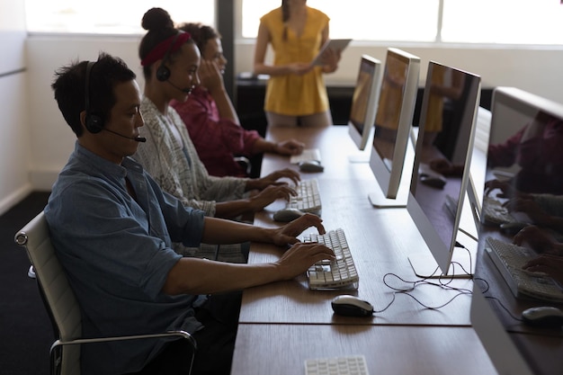 A diverse group of people participating in a job training program, with computers and instructors in the background. The scene emphasizes the opportunity for skill development and career advancement through government initiatives.