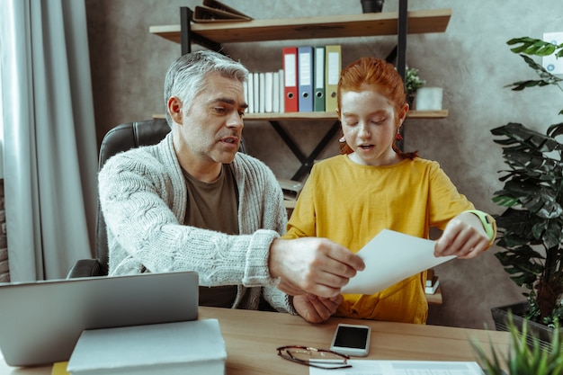 A family sitting at a table, reviewing tax documents and smiling. The scene conveys a sense of financial stability and access to tax benefits.