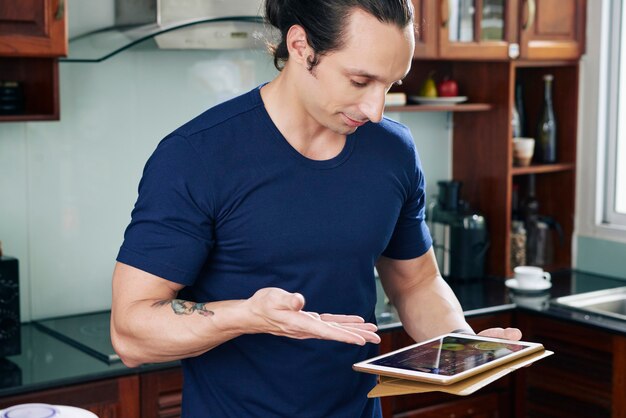 A doctor using a tablet to review data from a patient's wearable health tracker. The tracker is displayed on the patient's wrist, and the tablet shows detailed graphs of vital signs and activity levels. The doctor is explaining the data to the patient with a reassuring smile.