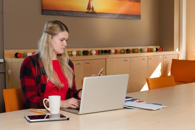 A person looking at a job board filling out application for unemployment benefits on their laptop in a bright, modern co-working space.