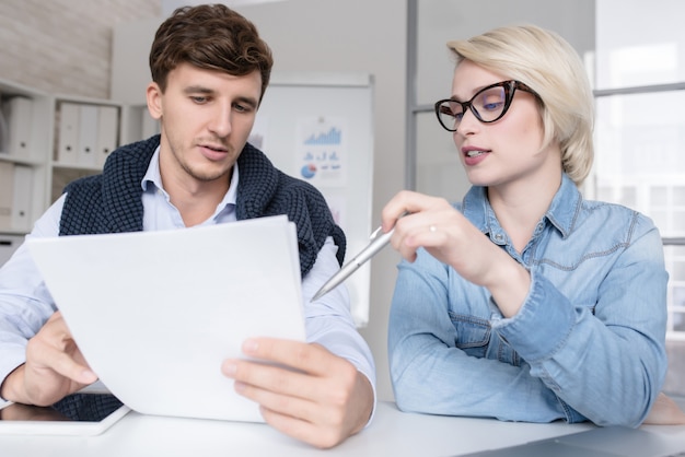 A financial advisor sitting across from an adult student, reviewing documents and gesturing towards a financial plan. The scene conveys trust, expertise, and personalized guidance in managing education finances.