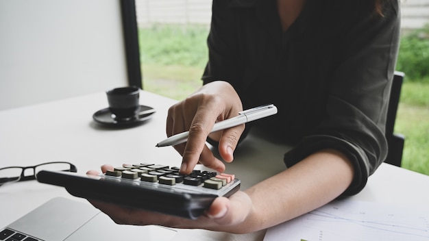 A person using a calculator while reviewing tax documents on a desk, highlighting the importance of understanding and utilizing tax credits for small business financial management.