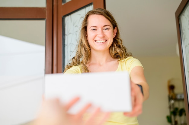 A smiling woman receiving a letter about her Social Security benefits, emphasizing the importance of opening and reviewing official communications.