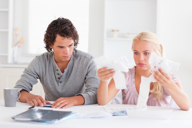 A family discussing their budget at a table, with bills and financial documents scattered around.