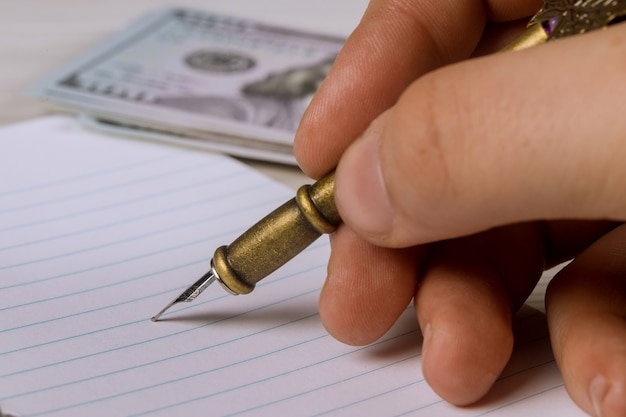 A close-up image showing the hand of a person signing a payday loan contract with a concerned expression on their face. The contract is partially visible, showing highlighted sections with high interest rates and fees. The overall tone is somber, emphasizing the risks associated with predatory lending practices.