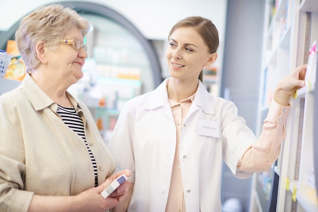 A senior citizen consulting with a pharmacist about their Medicare Part D plan options, emphasizing the value of personal guidance and professional advice.