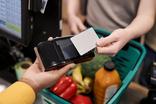 A close-up image of a SNAP card being used at a supermarket checkout, focusing on the electronic payment terminal.